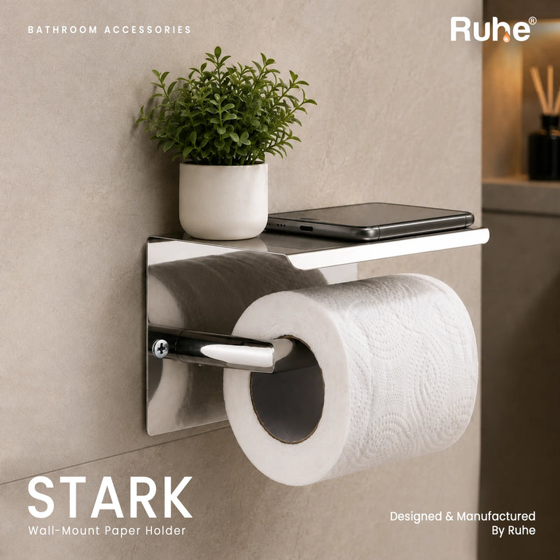 Stark toilet paper holder with phone shelf on a bathroom wall, with a phone on the shelf